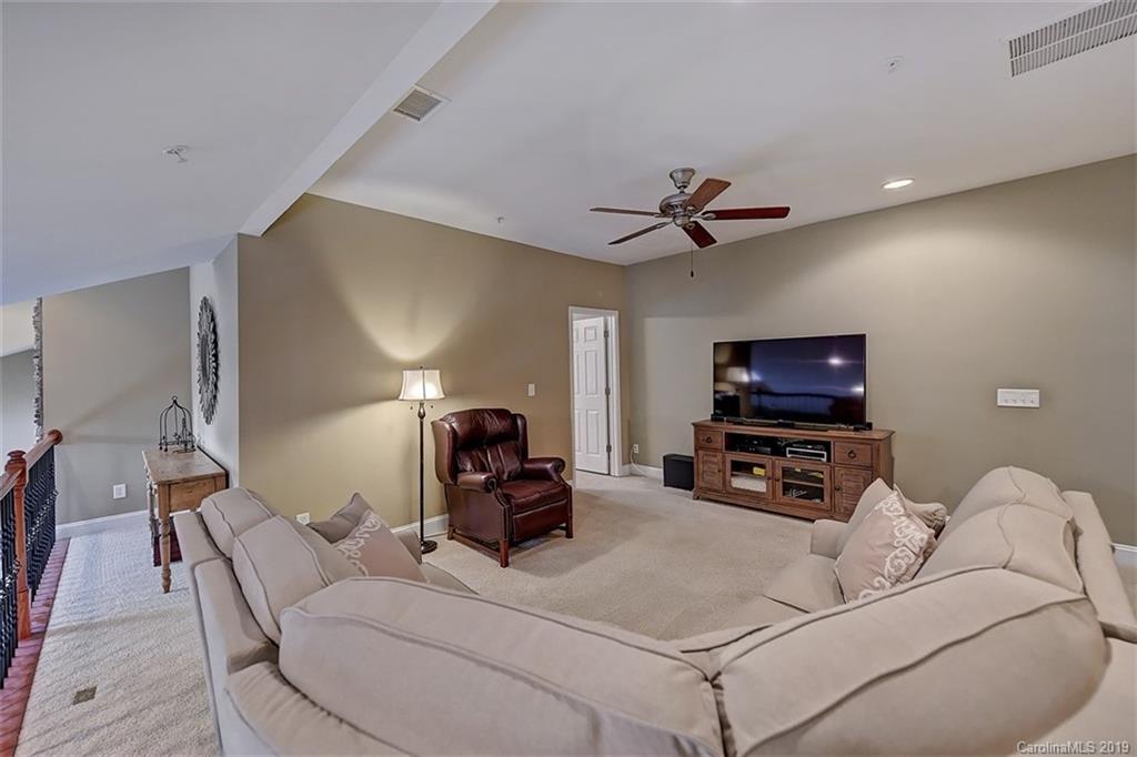 405 Halyard Lane Tega Cay, SC 29708 - Photo 35 of 48 a living room with furniture a ceiling fan and a flat screen tv