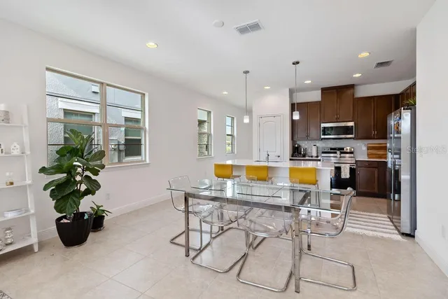 a dining room with furniture and large windows