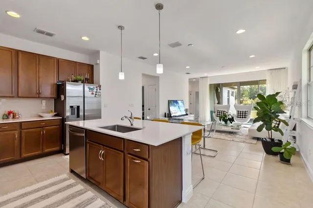 a kitchen with a sink a counter top space appliances and cabinets