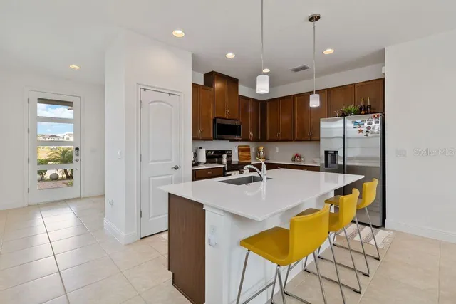 a kitchen with stainless steel appliances granite countertop a sink a stove and a refrigerator