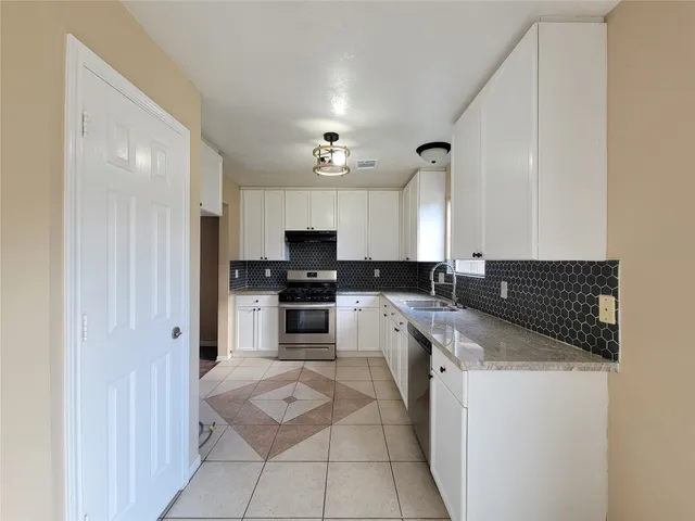 a kitchen with a sink cabinets and stainless steel appliances