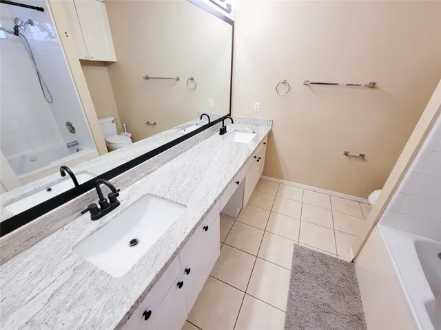 a bathroom with a tub sink and mirror