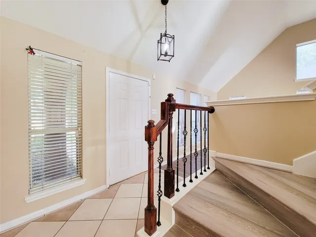 a view of a hallway with entryway and stairs