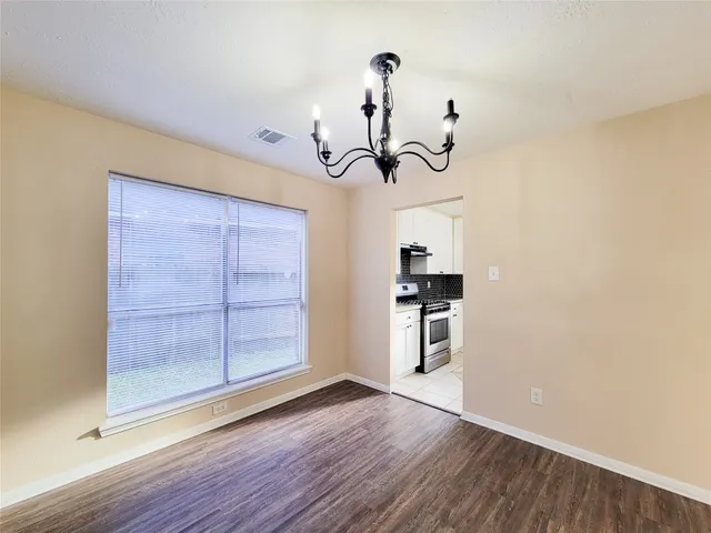 a view of a kitchen with wooden floor and a ceiling fan