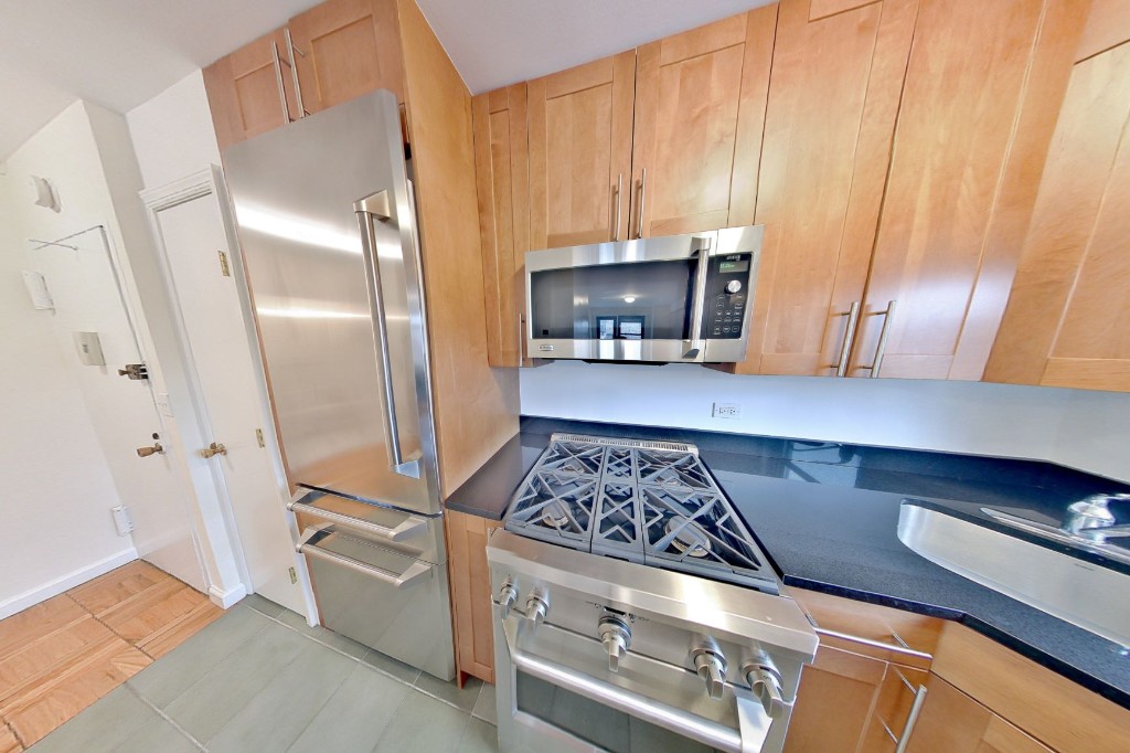 a kitchen with stainless steel appliances granite countertop a stove a refrigerator and a microwave