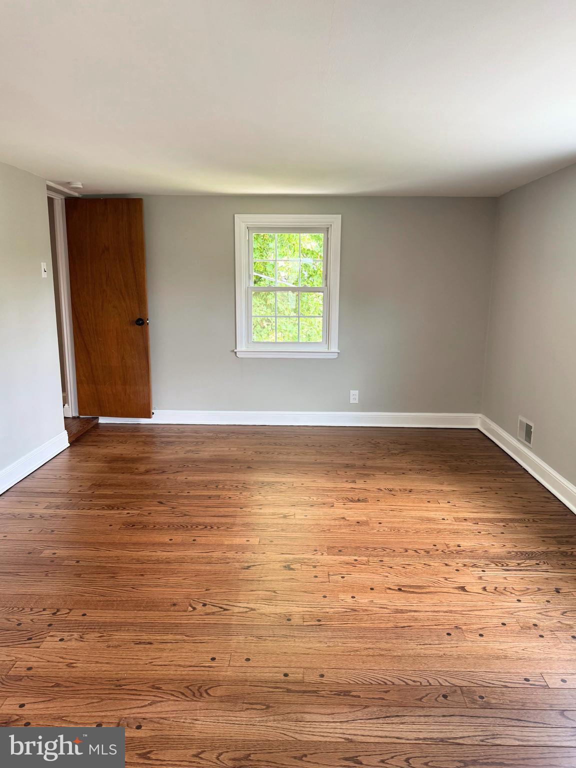 563 Rutherford Drive Springfield, PA 19064 - Photo 14 of 28 a view of an empty room with wooden floor and a window