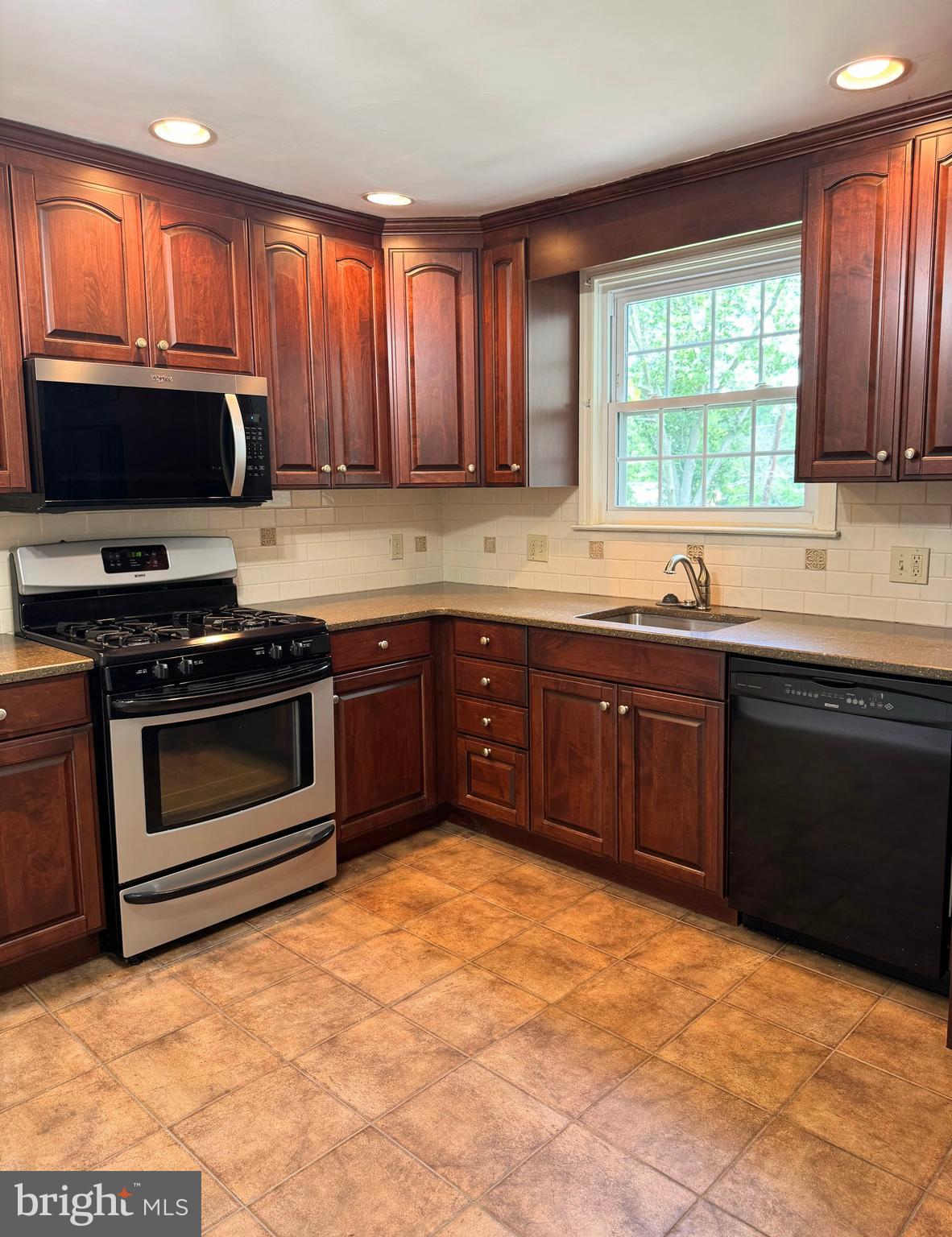 563 Rutherford Drive Springfield, PA 19064 - Photo 7 of 28 a kitchen with stainless steel appliances granite countertop a stove sink and microwave