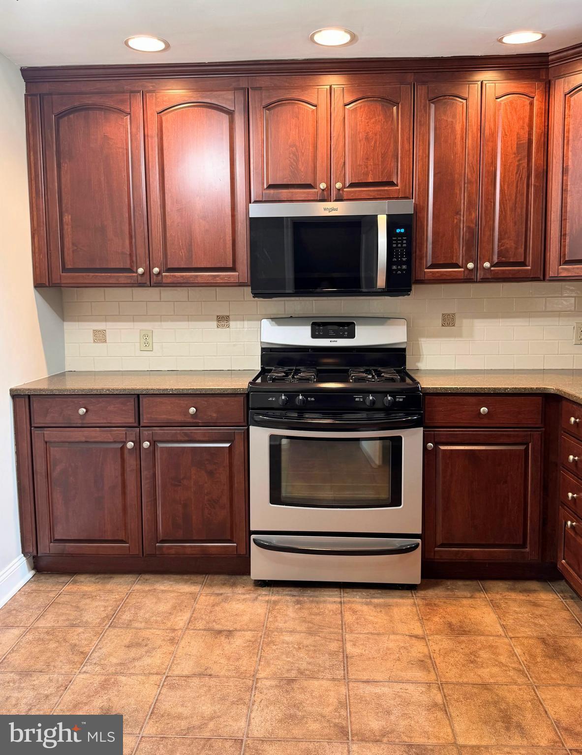 563 Rutherford Drive Springfield, PA 19064 - Photo 9 of 28 a kitchen with granite countertop a stove and a microwave