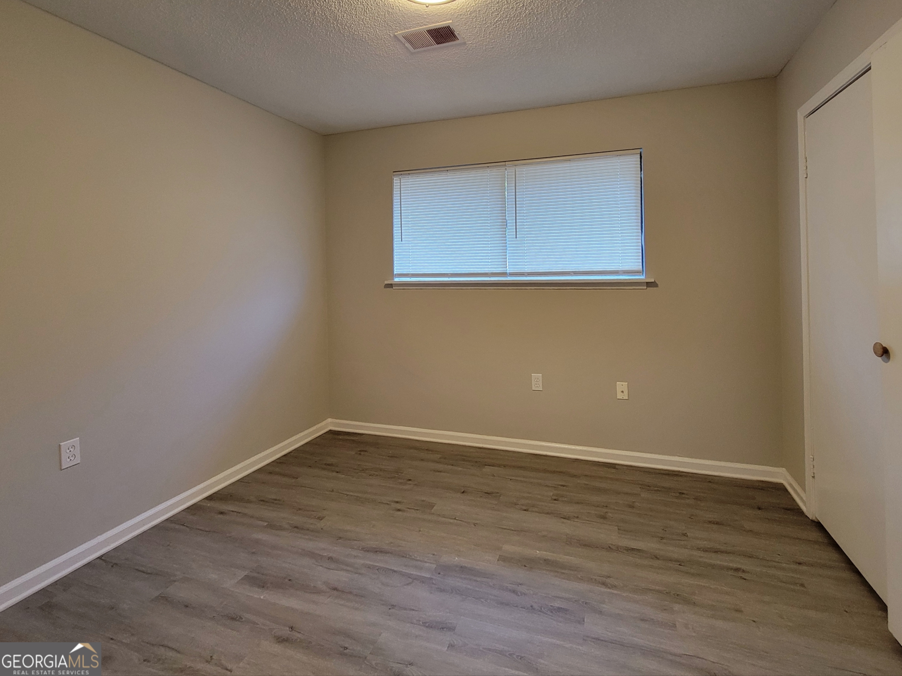 422 Highway 211 Street Northwest, Unit F Winder, GA 30680 - Photo 8 of 9 an empty room with wooden floor and windows
