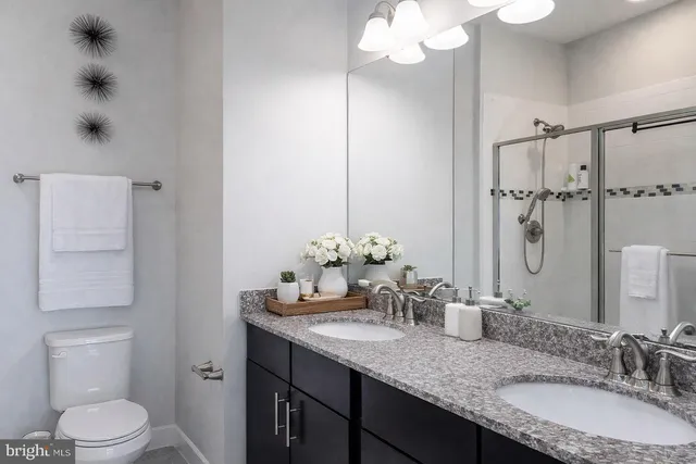 a bathroom with a granite countertop sink a toilet and a mirror