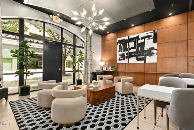 a living room with furniture a chandelier and a floor to ceiling window