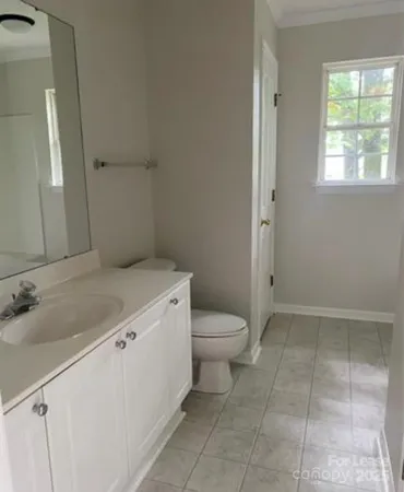 a bathroom with a granite countertop sink a toilet and a mirror
