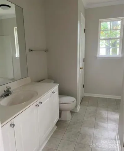 a bathroom with a granite countertop sink a toilet and a mirror