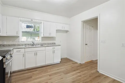 a kitchen with granite countertop white cabinets and white appliances