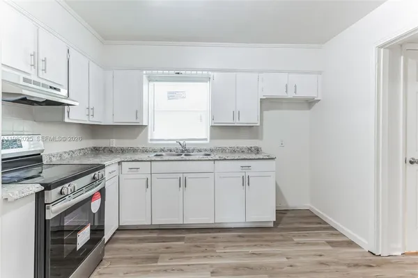 a kitchen with granite countertop white cabinets and white appliances