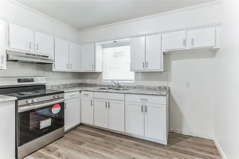 a kitchen with granite countertop wooden cabinets stainless steel appliances and a counter space