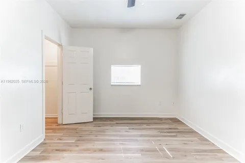 a view of a small space with wooden floor and a window
