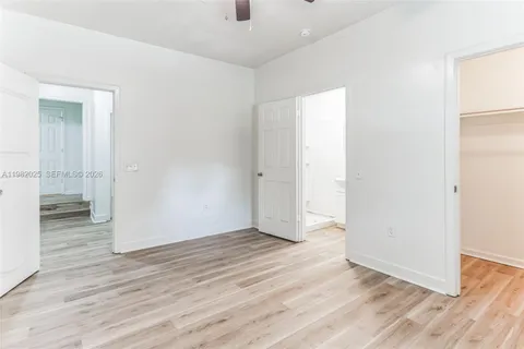 an empty room with wooden floor & windows