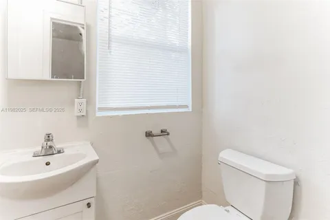 a white toilet sitting next to a white sink