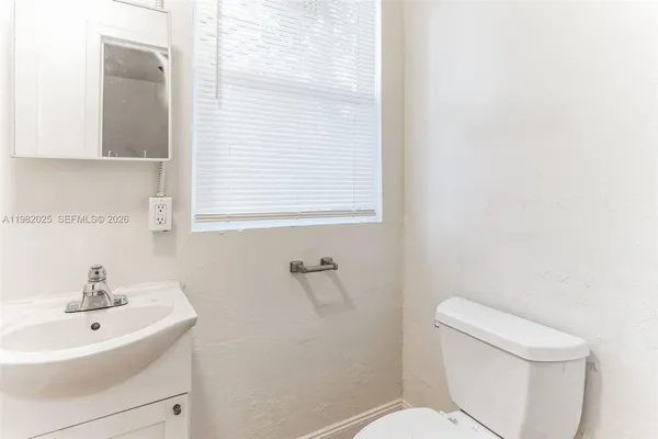 a white toilet sitting next to a white sink