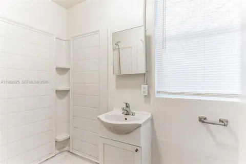 a bathroom with a sink shower and a mirror