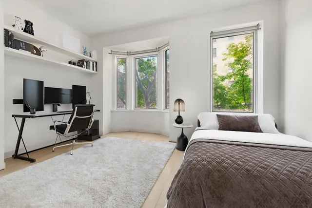 a bedroom with bed tv and window