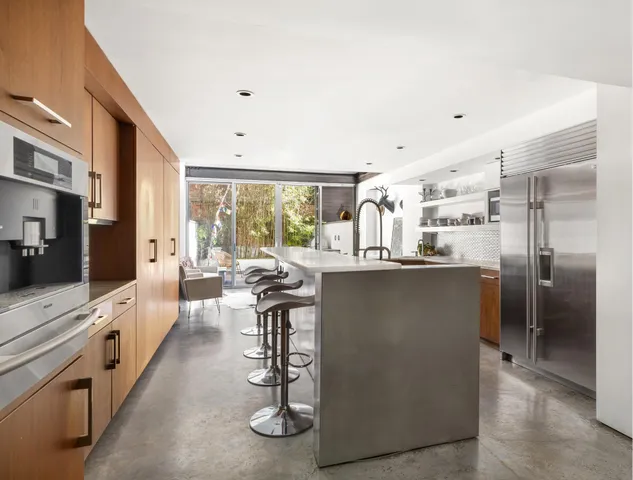 a kitchen with stainless steel appliances kitchen island granite countertop a refrigerator and a stove top oven