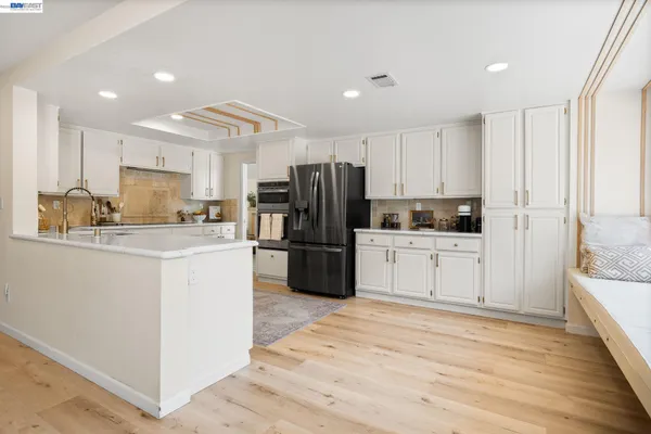 a kitchen with white cabinets and stainless steel appliances