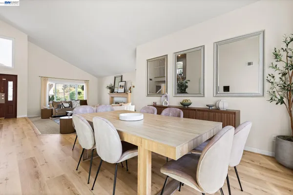 a view of a a dining room with furniture window and wooden floor