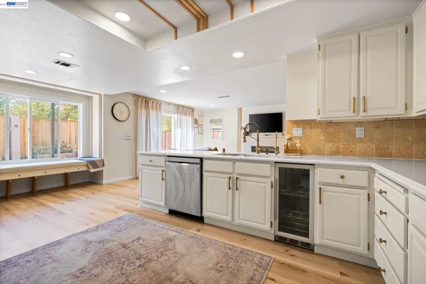 a kitchen with granite countertop a sink cabinets and stainless steel appliances