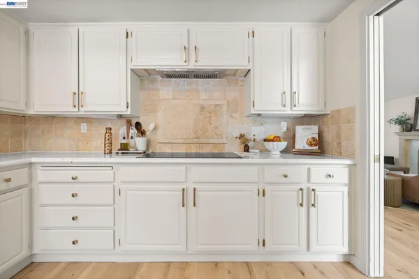 a kitchen with granite countertop white cabinets and white appliances