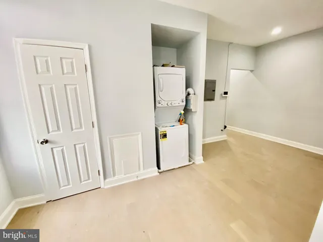 a view of a livingroom with a kitchen space and a refrigerator