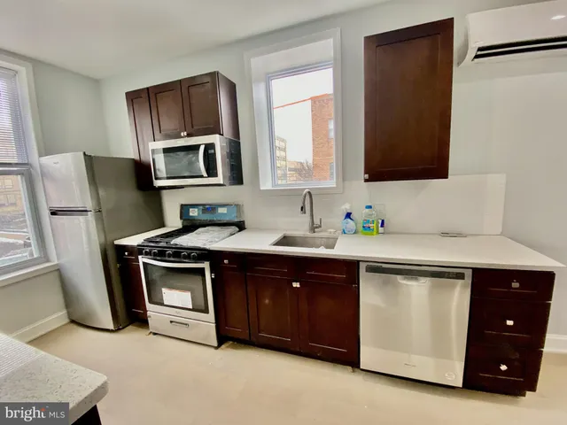 a kitchen with stainless steel appliances a sink stove and refrigerator