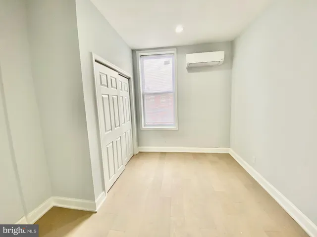 a view of an empty room with a kitchen and a window