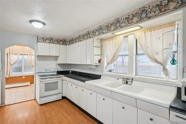 a kitchen with granite countertop a sink and a stove top oven