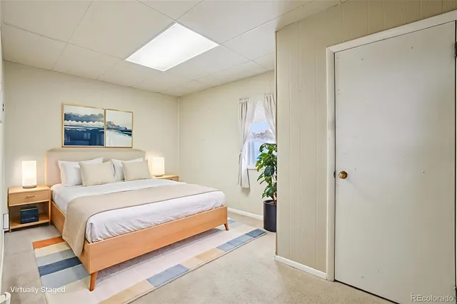 a bedroom with a bed and a painting on the wall