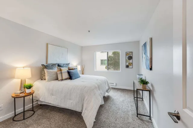 a spacious bedroom with a bed and painting on the wall
