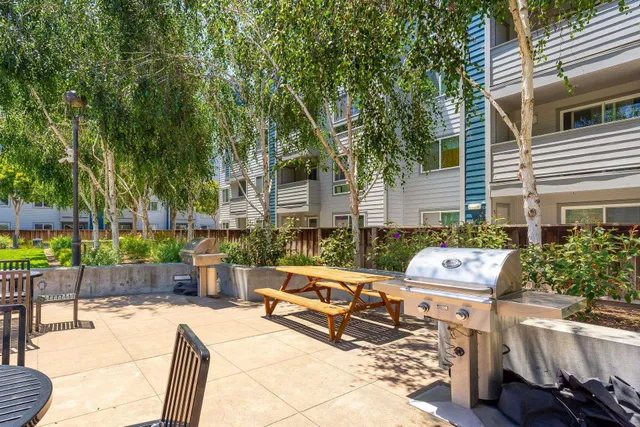 a view of a patio with couches table and chairs and potted plants