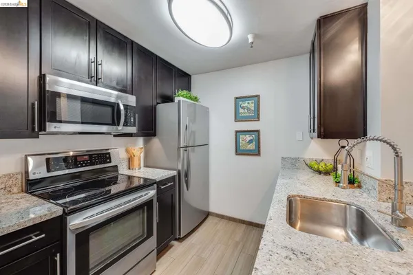 a kitchen with stainless steel appliances granite countertop a sink stove and refrigerator