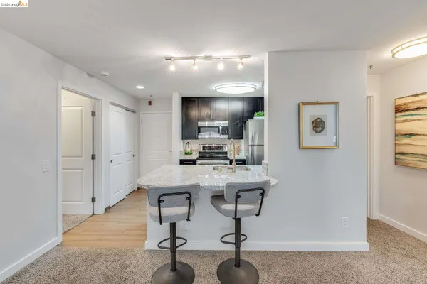 a view of a kitchen with kitchen island a counter top space a sink and appliances