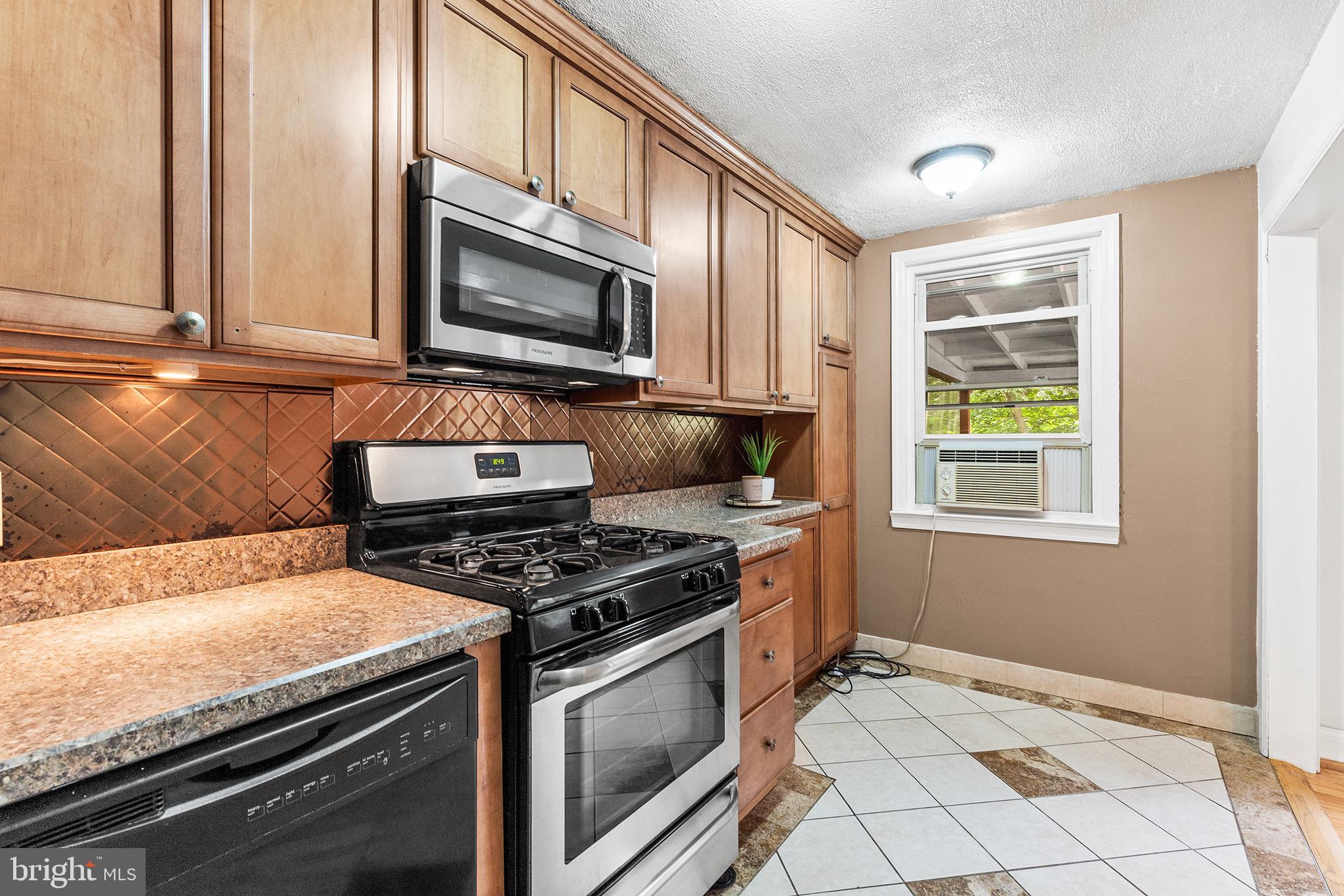 390 Glen Cove Road Collingdale, PA 19023 - Photo 9 of 27 a kitchen with granite countertop a stove top oven cabinetry a sink and a window