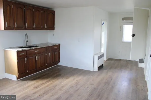 a kitchen with stainless steel appliances granite countertop a stove a refrigerator and a cabinets with wooden floor