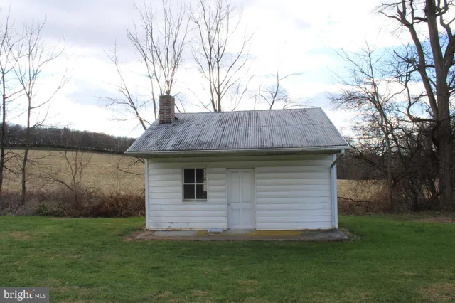 a view of a backyard with barn and a large tree