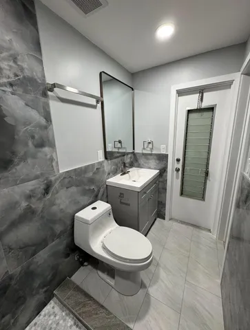 a white toilet sitting next to a bathroom sink