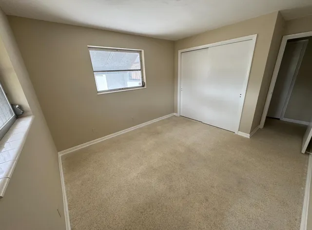 an empty room with windows and closet