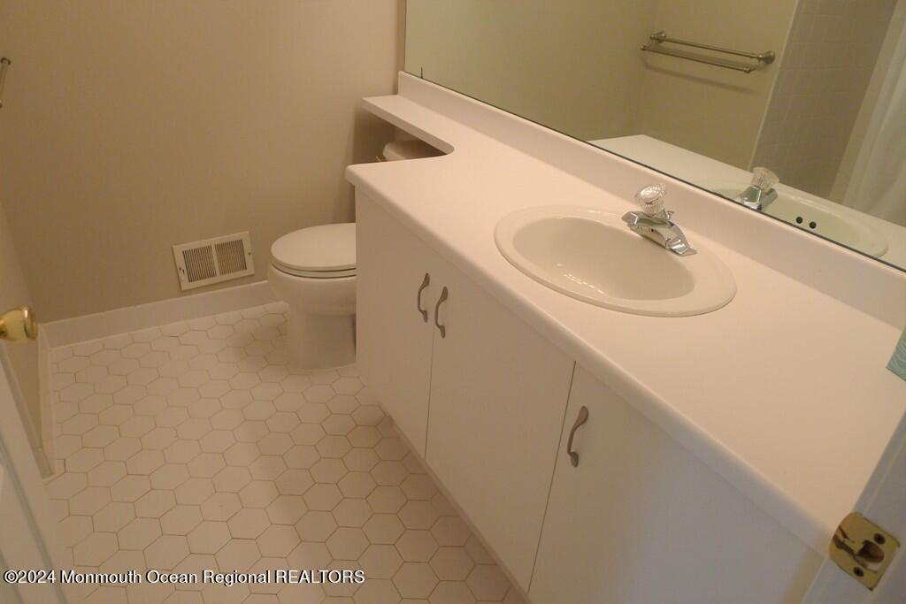a bathroom with a sink a toilet and mirror