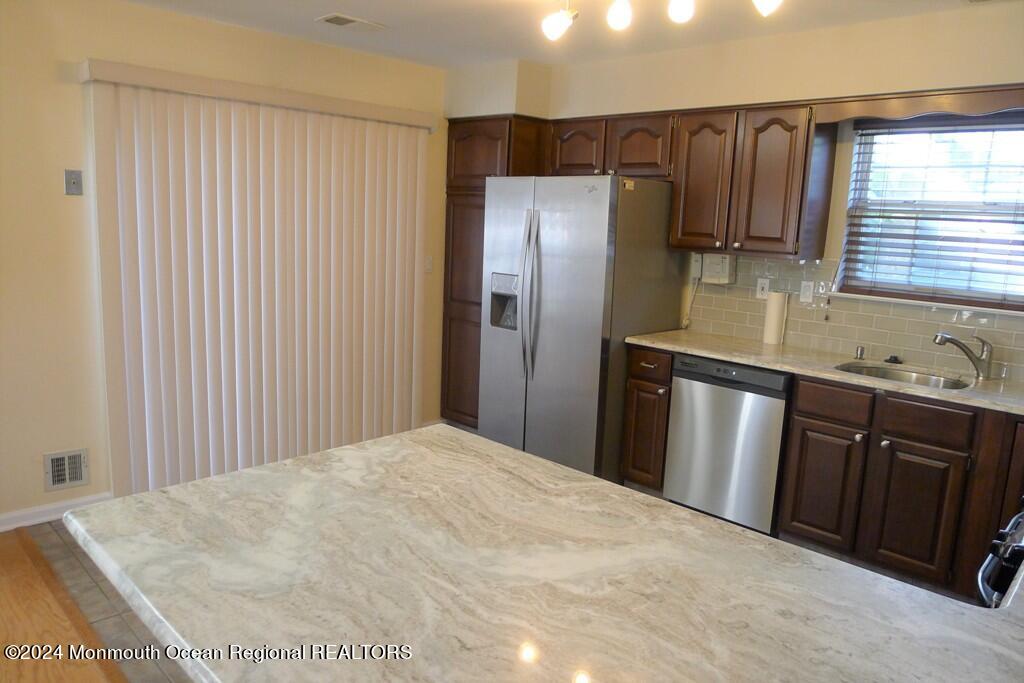 5 Oxford Road Holmdel, NJ 07733 - Photo 13 of 16 a kitchen with stainless steel appliances granite countertop a refrigerator and wooden cabinets