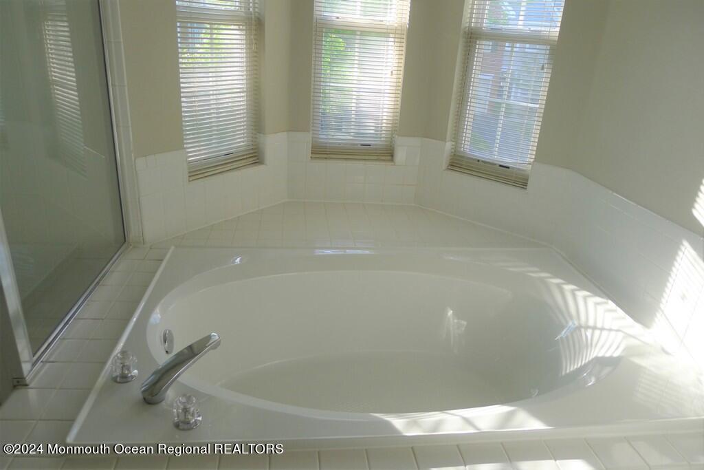 5 Oxford Road Holmdel, NJ 07733 - Photo 3 of 16 a bath tub sitting in a bathroom next to a window
