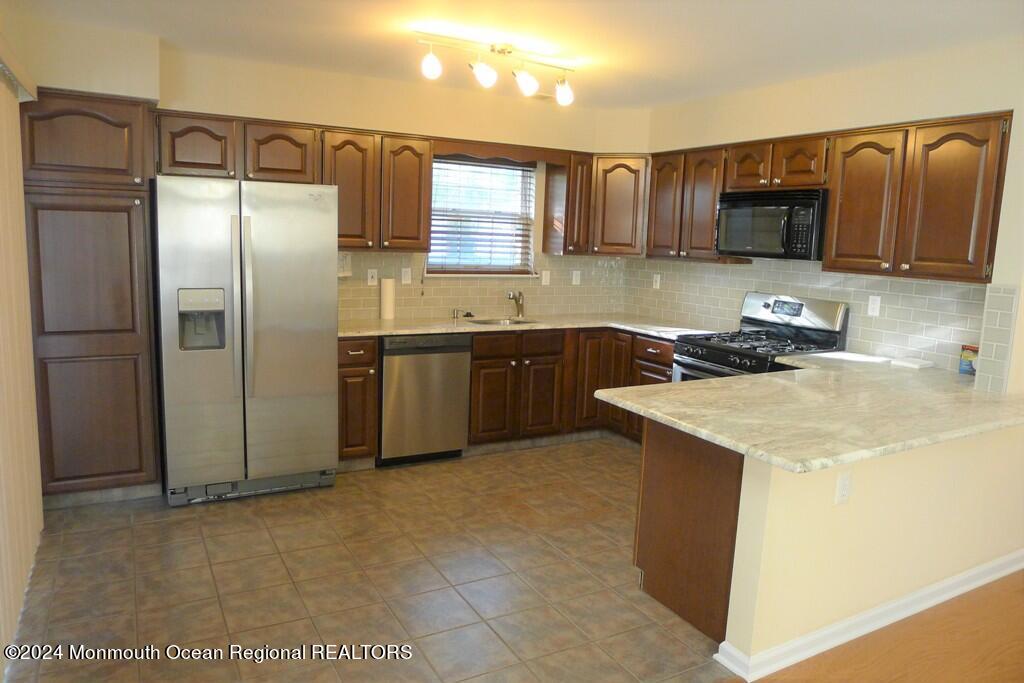 5 Oxford Road Holmdel, NJ 07733 - Photo 10 of 16 a kitchen with stainless steel appliances granite countertop a sink stove and refrigerator