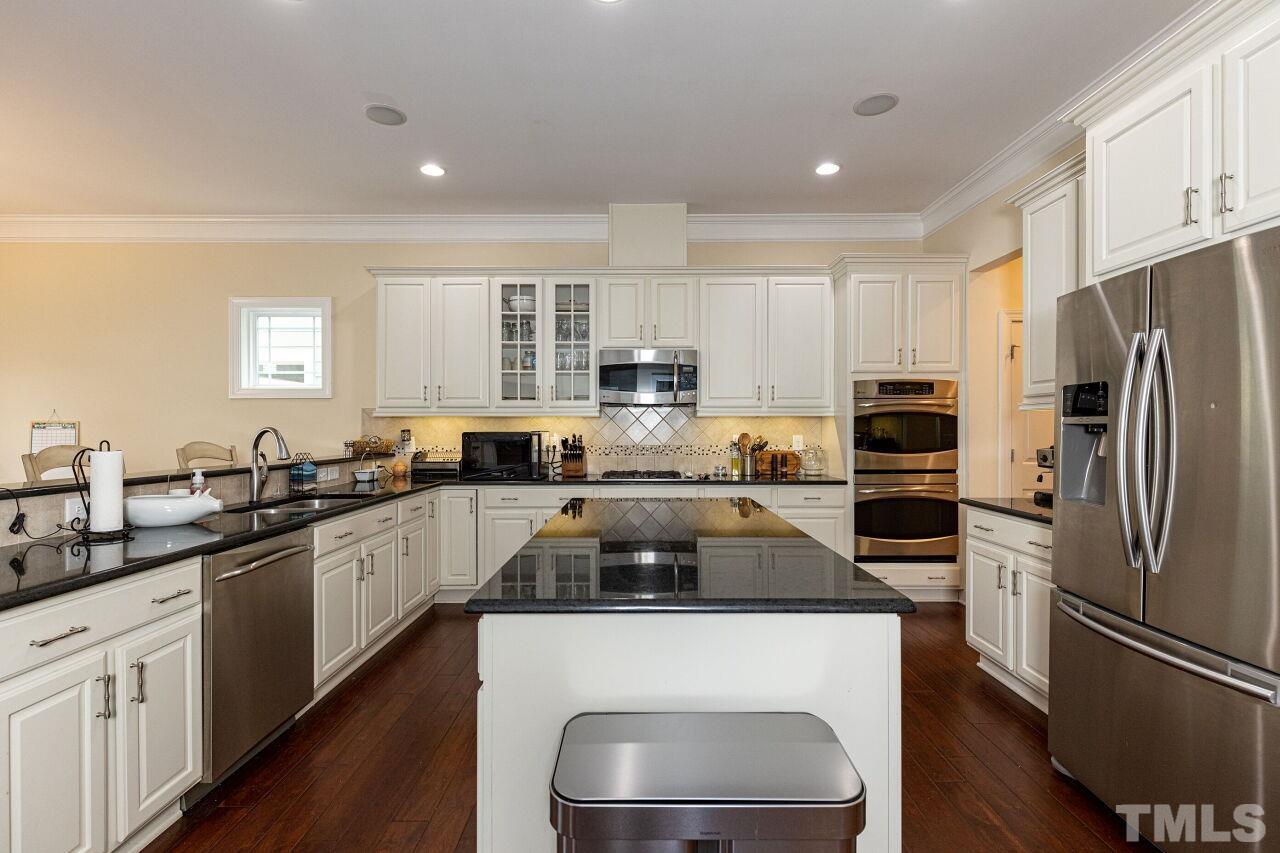 1536 Rodessa Run Raleigh, NC 27607 - Photo 12 of 53 a kitchen with a refrigerator a sink a stove a microwave and cabinets